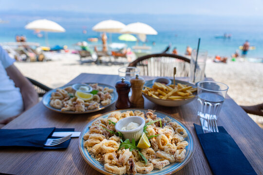 eating fried squid calamari with a sea view from the beach bar in croatia