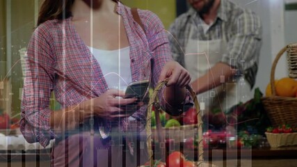 Animation of financial data over hands of caucasian woman using smartphone and shopping at market - Powered by Adobe