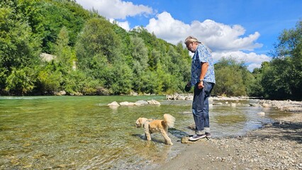 Mann mit seinem Hund am Flu&szlig; 