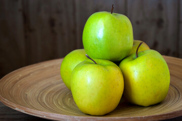 green apples on a wooden plate