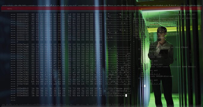 IT specialist wearing suit surveying racks in server room aisle, with hex code overlay, copy space