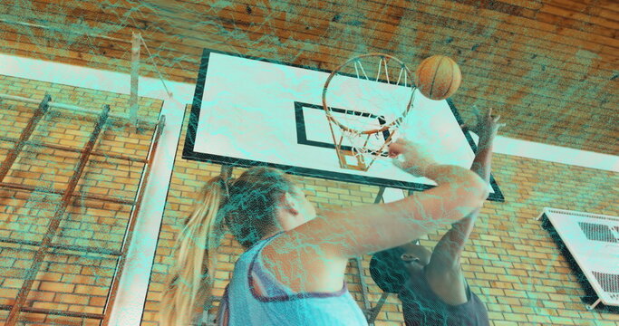 Fototapeta Reaching athlete in blue jersey shooting orange basketball at gym, with male opponent blocking hoop