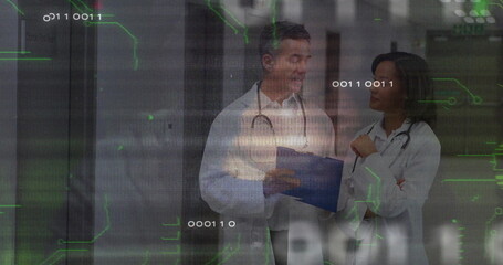 Standing two doctors consulting over blue clipboard in hospital corridor, with data overlay