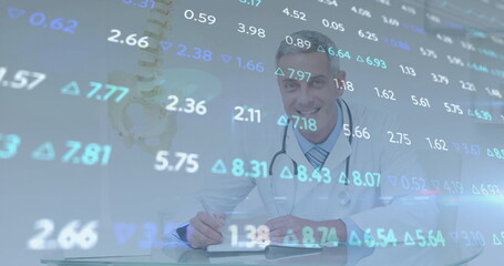 Logging Dr wearing lab coat and stethoscope taking notes in notebook in clinic, spine model overlay
