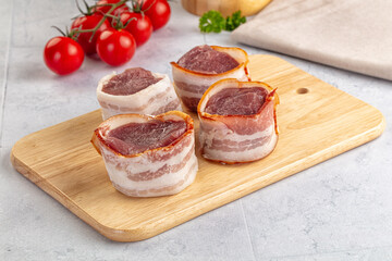 Raw pork tenferloin with bacon