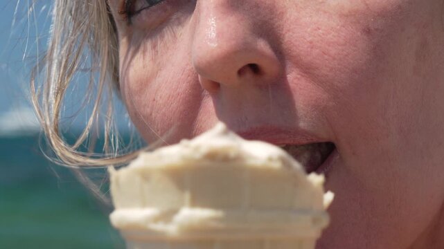 Ice cream, woman, eating a refreshing cone at the sunny beach, enjoying summer vacation