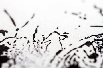 Extreme close up of black acrylic paint texture on paper. Selective focus.