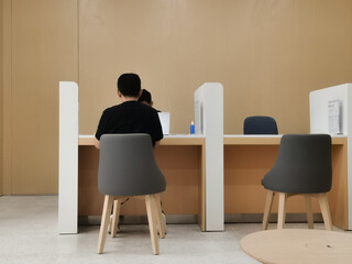 Customers at a minimalist service counter with modern chairs.