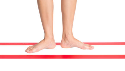 Bare feet and lower legs balancing on two parallel red slacklines