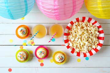 Colorful party treats and popcorn with festive lanterns overhead