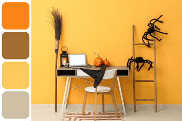 Workplace with laptop, pumpkins and broom in comfortable office interior decorated for Halloween celebration