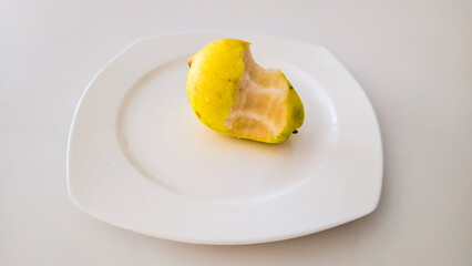 Bitten Pear on Plate White Background