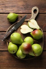 Fresh ripe pears and knife on wooden table, top view