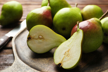 Fresh ripe pears and knife on wooden table, closeup