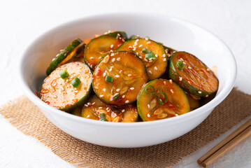 Korean cucumber salad (Oi muchim) in bowl on white background, Korean side dish