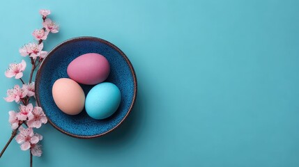 Obraz premium Easter Eggs in Bowl with Blossoms on Blue Background