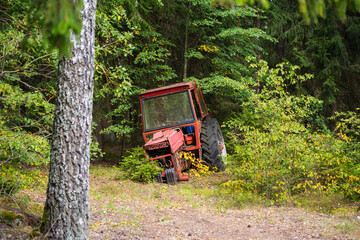 an old, dilapidated tractor abandoned in the forest