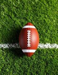 American football on a green field, centered on the white line