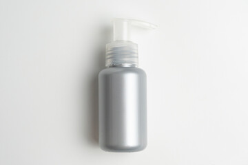 Gray beauty liquid serum blank bottle on white isolated background. Gray pump bottle with blank label on neutral background, perfect for beauty, shampoo, skin mock up bottle. 