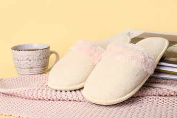 White slippers, cup of coffee and magazine on yellow background
