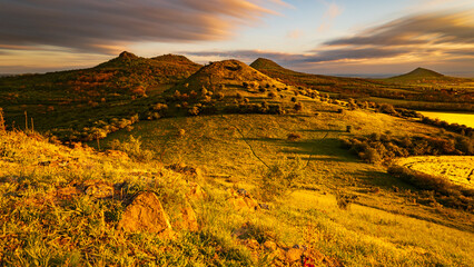 Sunset over the rolling hills of the Bohemian Central Highlands in the Czech Republic, with vibrant...