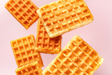Falling waffles on pink background