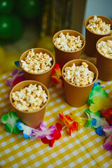 Paper cups with popcorn on festive table