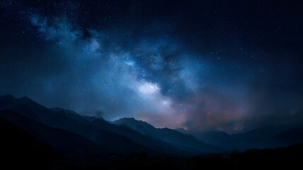Majestic Milky Way galaxy illuminating a vast night sky above dark mountain silhouettes creating a serene cosmic landscape
