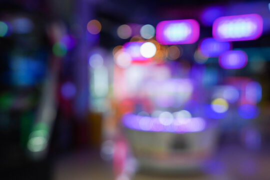 Defocused view of amusement Arcade game center. Toy crane game vending machine