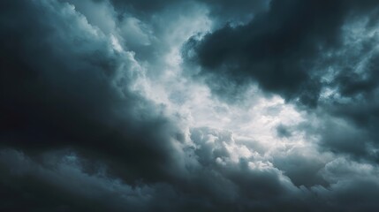 Obraz premium Dramatic dark storm clouds fill an overcast sky before rainfall creating a moody and powerful natural weather scene with striking light