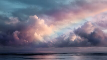 A serene pastel sunset or sunrise illuminates a dramatic cloudy sky over the tranquil ocean creating a picturesque and colorful seascape with