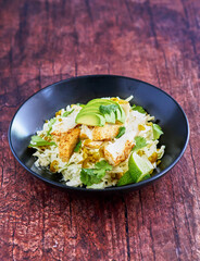fish taco bowl with shredded cabbage, sliced avocado, fresh cilantro, lime juice and sauteed fish