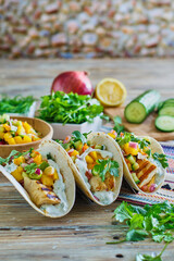 fish tacos made with fresh mahi, mango salsa, jalapeno, cucumber, lime crema, cilantro and flour tortilla