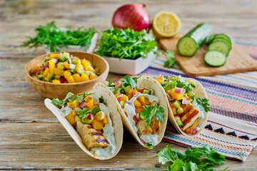 fish tacos made with fresh mahi, mango salsa, jalapeno, cucumber, lime crema, cilantro and flour...