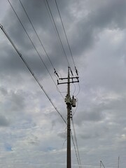 electric utility pole with power lines against cloudy sky