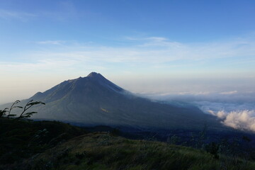 Fototapeta premium The savannah on Mount Merbabu with Mount Merapi in the background. Central Java, Indonesia