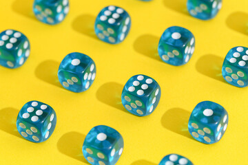 Blue game dices on yellow background, closeup