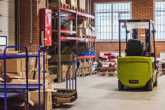 Forklift operation in a busy warehouse during afternoon hours under natural light
