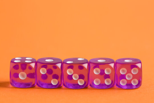 Purple game dices on orange background