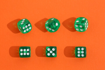 Green game dices on orange background