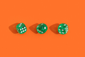 Green game dices on orange background