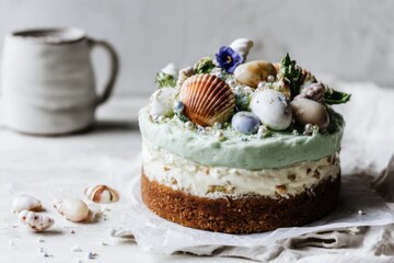 A beautifully crafted birthday cake showcases a mermaid theme, topped with colorful seashells, pearls, and edible flowers, celebrating a joyous occasion filled with oceanic charm