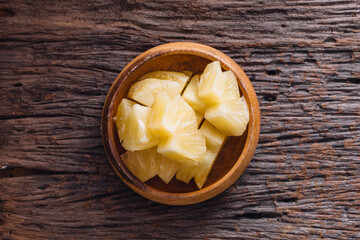 Fresh Pineapple Cubes in Wooden Bowl on Rustic Wooden Table