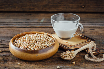 Soy Milk in Glass Cup with Raw Soybeans on Wooden Table Surface