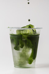 Green Drink with Liquid Swirl and Ice in Transparent Cup