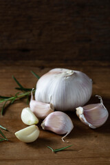 Fresh Garlic Bulbs and Cloves on Wooden Background with Herbs