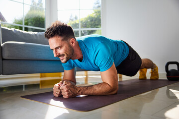 Adult man doing plank exercise during home workout