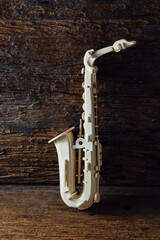 Naklejka premium Elegant Wooden Saxophone Sculpture on Rustic Wooden Background