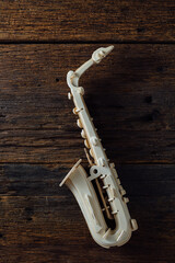 Naklejka premium Elegant White Saxophone on Rustic Wooden Background with Texture