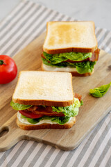 Homemade BLT (Bacon Lettuce Tomato) Sandwich with Mayo, side view. Close-up.
